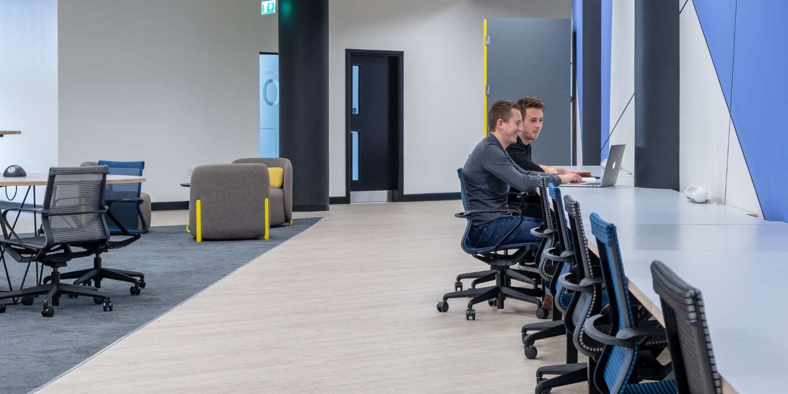 Mosaic coworking desk  space with two people working on a laptop