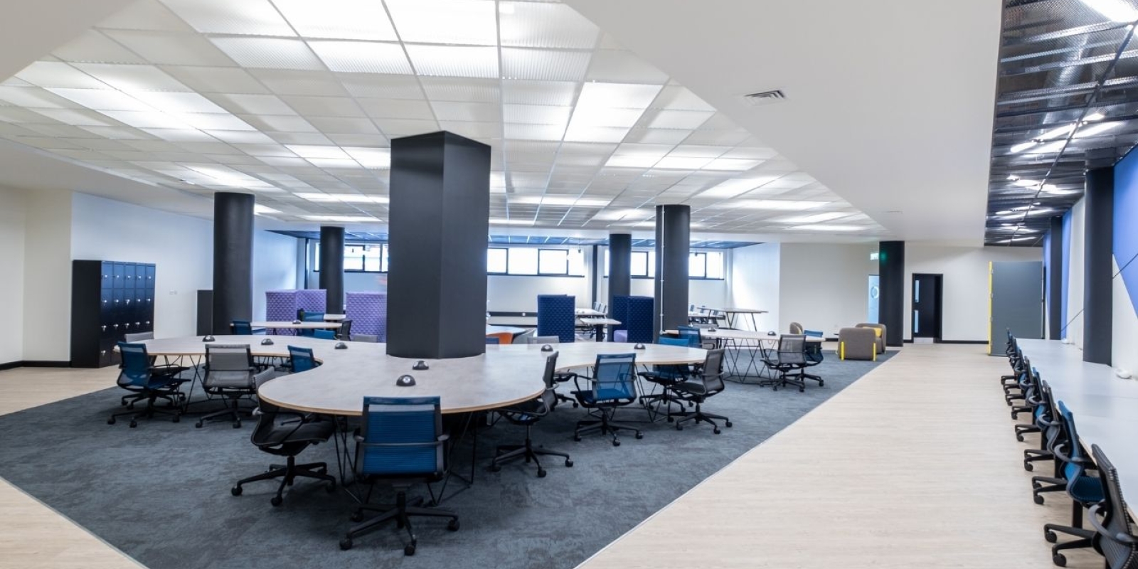 Dedicated desks upstairs at Mosaic with monitors, chairs and natural light